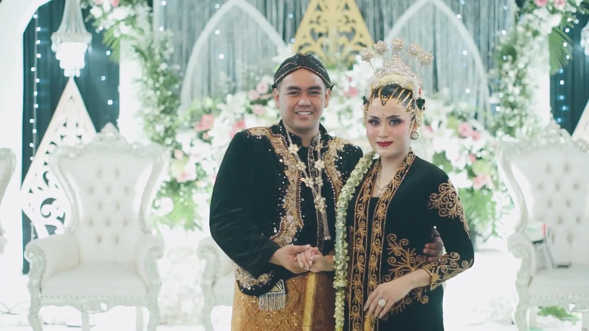 Pasangan pengantin berbusana beludru hitam