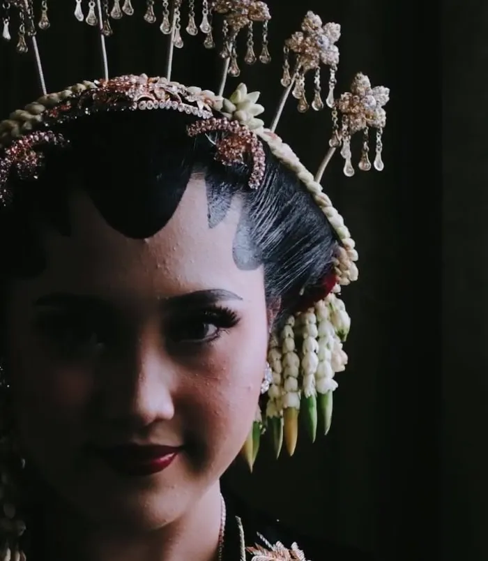 Pengantin wanita dengan paes Jawa dalam cahaya redup