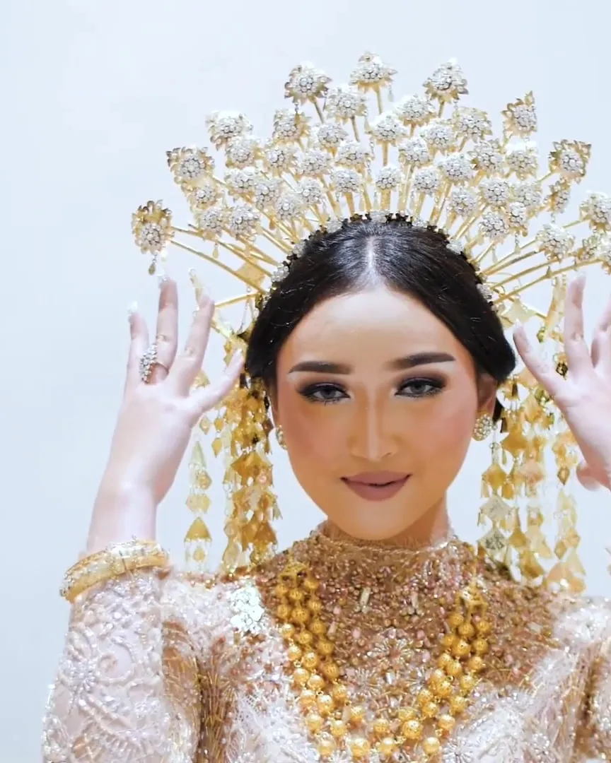 Model mengenakan mahkota emas dan kebaya payet di fashion show House of Verza