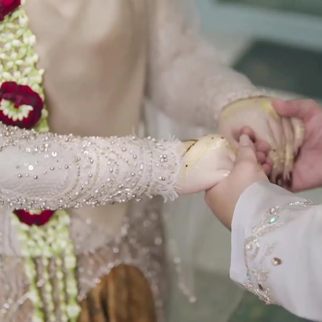 Tangan pasangan pengantin saling menggenggam